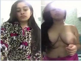 A stunning girl strips down to reveal her ample breasts
