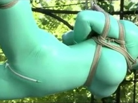 Watch as a submissive is restrained in latex and taken for a wild ride outside