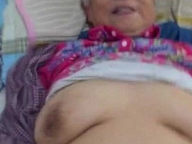 Precisely aimed Chinese elderly woman engages in sexual activity while showcasing saggy breasts