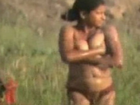 Nude Indian teen takes a bath in the field